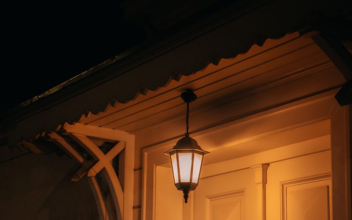 Warm beleuchteter Hauseingang mit Laterne bei Nacht