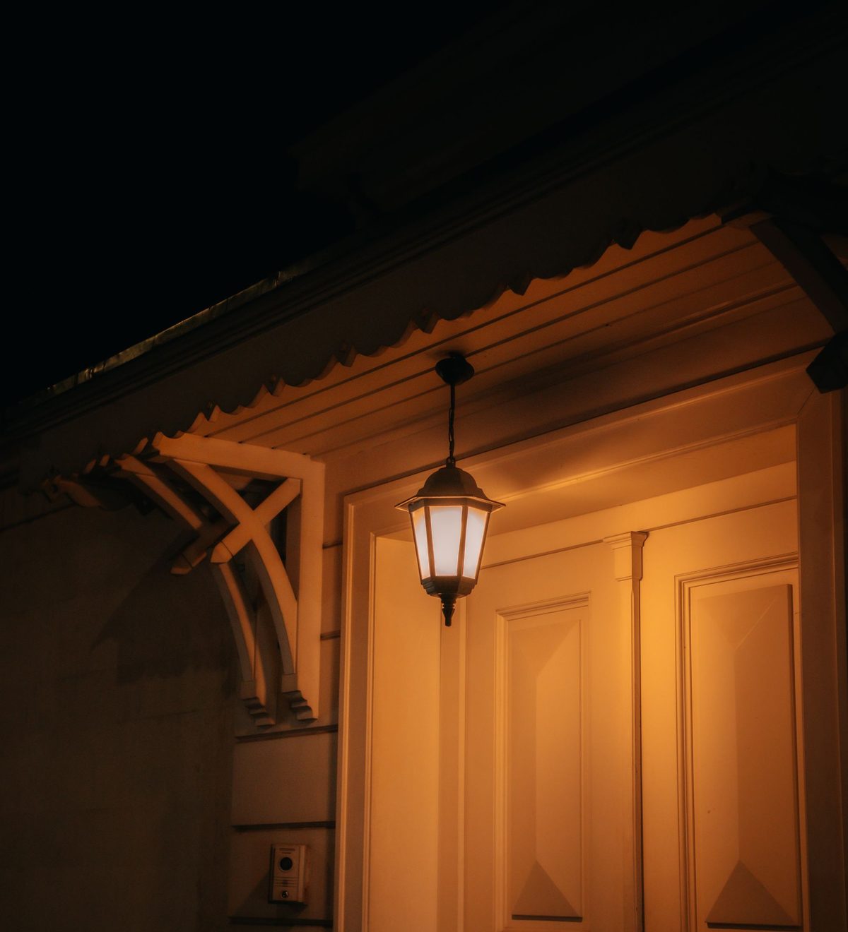 Warm beleuchteter Hauseingang mit Laterne bei Nacht