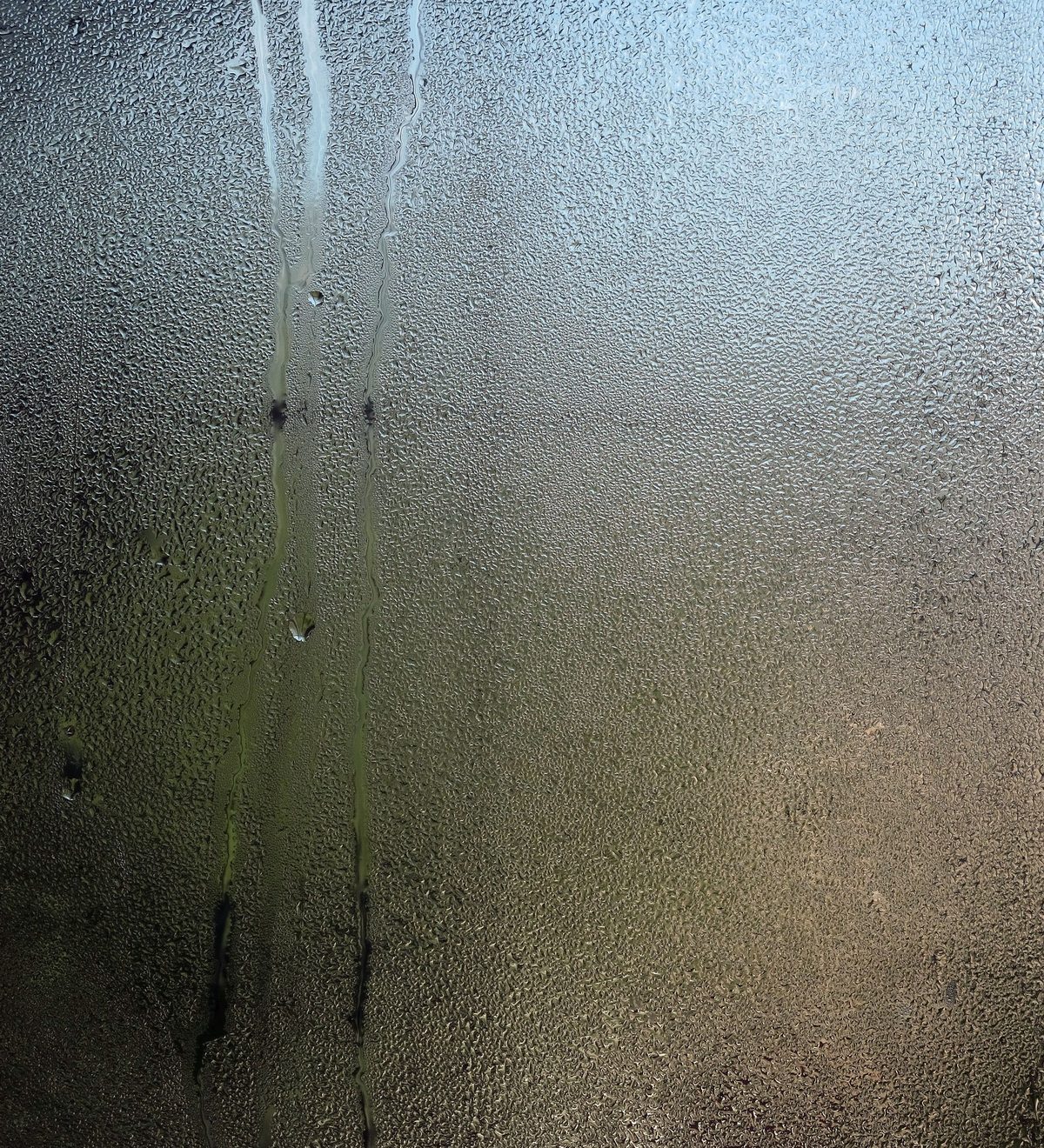 Kondenswasser läuft an einer beschlagenen Fensterscheibe herunter