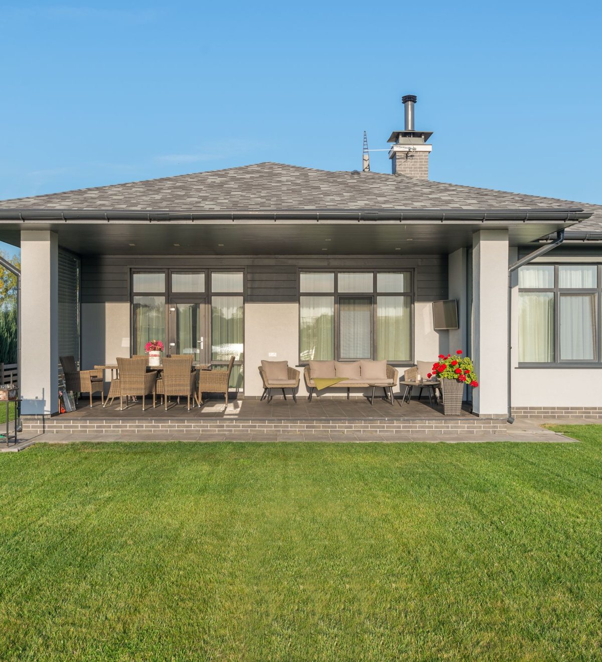 Moderner Bungalow mit überdachter Terrasse und frisch gemähtem, gepflegtem Rasen