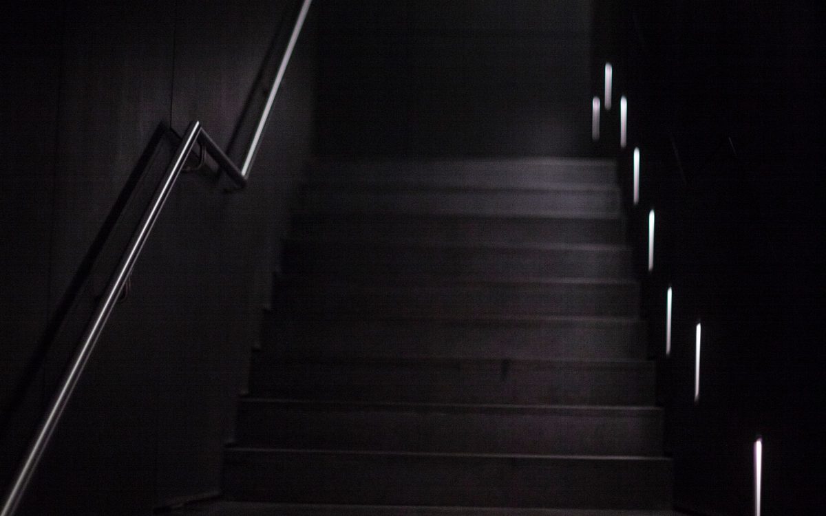 Dunkle Treppe mit kleinen Lichtern an den Stufen