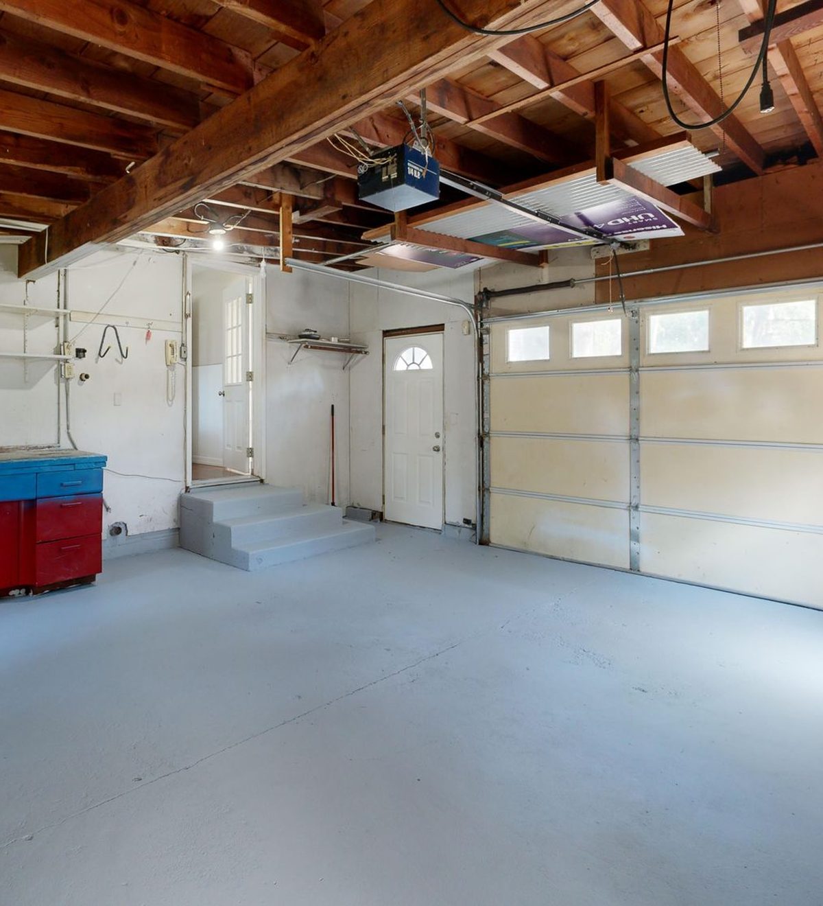 Aufgeräumte, helle Garage mit Holzbalkendecke und Werkbank