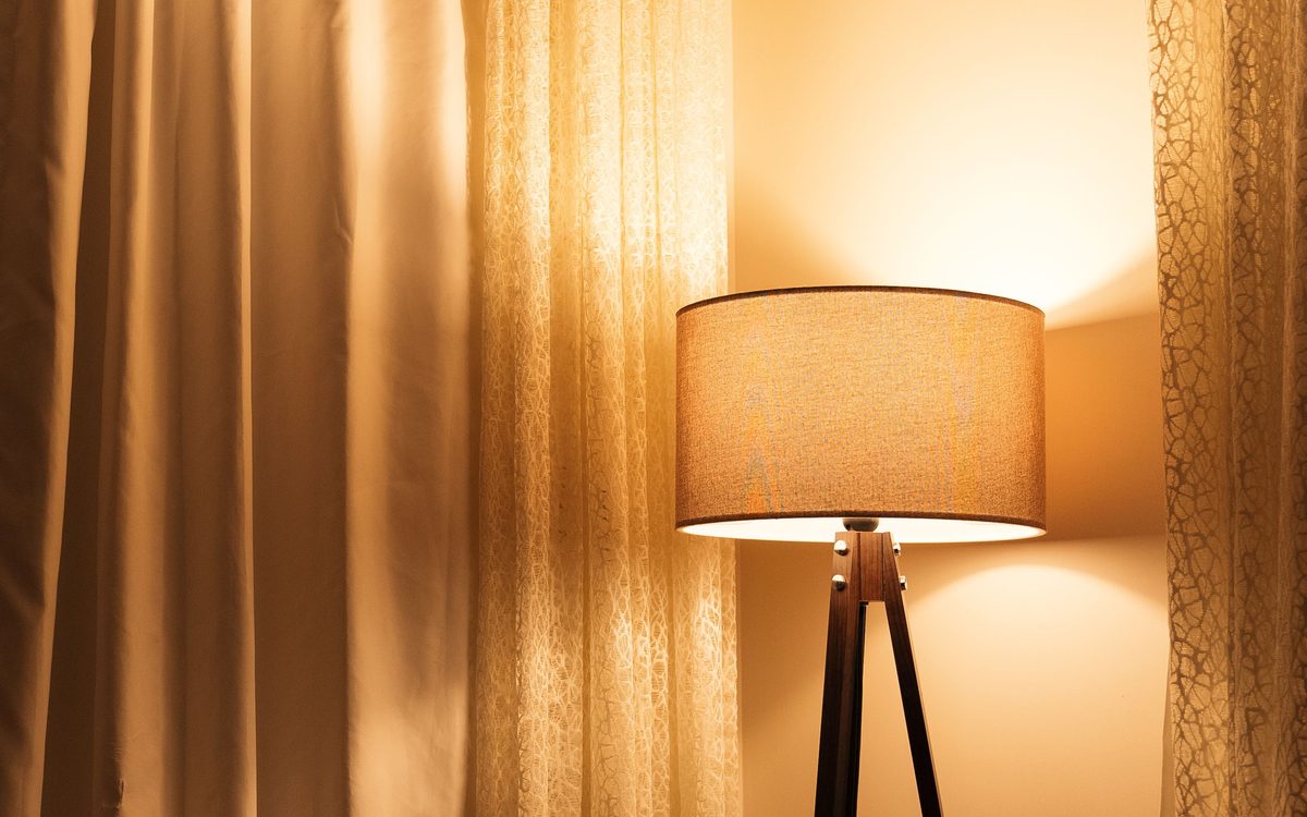 Warm leuchtende Stehlampe in einer gemütlichen Zimmerecke
